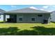 Rear view of a single-story house with covered patio and grassy yard at 3882 Willow Ridge Dr, Lakeland, FL 33810