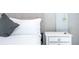 Close up of a bedroom with a white nightstand and bedding at 1692 Tropical Palms Cir, Kissimmee, FL 34747