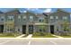 Three-unit townhome building, gray siding, stone accents, and landscaping at 1692 Tropical Palms Cir, Kissimmee, FL 34747