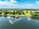 Aerial view showcasing a waterfront property with lush green lawns and a private dock at 9400 Laws Rd, Clermont, FL 34714