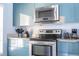 Modern kitchen with stainless steel appliances and teal cabinets at 3004 White Orchid Rd, Kissimmee, FL 34747