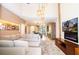 Spacious living room with L-shaped sectional sofa, fireplace, and large TV at 7487 Brooklyn Dr, Kissimmee, FL 34747