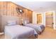 Two twin beds in a well-lit bedroom with wood-paneled accent wall at 7487 Brooklyn Dr, Kissimmee, FL 34747
