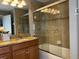 Bathroom with granite countertop, shower/tub combo, and wood cabinets at 2937 Banana Palm Dr, Kissimmee, FL 34747