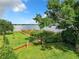 Backyard oasis with lake access, wooden dock, lush lawn, and mature trees providing shade at 33 S Ortman Dr, Orlando, FL 32805