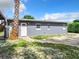 Gray house exterior with white door, landscaping, and a paved driveway at 33 S Ortman Dr, Orlando, FL 32805