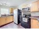 Kitchen with light wood cabinets, black appliances, and granite countertops at 33 S Ortman Dr, Orlando, FL 32805