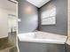 Corner jacuzzi tub with gray walls and tiled floor at 33 S Ortman Dr, Orlando, FL 32805