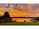 Stunning sunset over the lake, showcasing a boathouse and tranquil waterfront property at 301 Richard Pl, Orlando, FL 32806