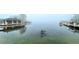 Serene waterfront view on a foggy morning, featuring private boat docks and calm waters at 301 Richard Pl, Orlando, FL 32806