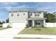 Two-story house with gray siding, white garage door, and landscaped front yard at 1186 August Sky Dr, Deltona, FL 32738