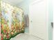 Clean bathroom with floral shower curtain and a door to another room at 1186 August Sky Dr, Deltona, FL 32738