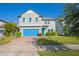 Two-story home with gray siding, blue garage door, and landscaped yard at 14166 Dove Hollow Dr, Orlando, FL 32824