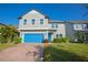 Two-story home with gray siding, blue garage door, and landscaped yard at 14166 Dove Hollow Dr, Orlando, FL 32824