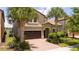 Two-story house with a brown garage door and palm trees at 8841 Rhodes St, Kissimmee, FL 34747