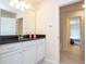 Bathroom with white cabinets, dark countertop, and a view into another room at 8841 Rhodes St, Kissimmee, FL 34747