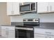 Modern kitchen featuring stainless steel stove and microwave at 4278 Green Gables Pl, Kissimmee, FL 34746
