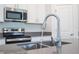Modern kitchen sink with stainless steel appliances and gray countertop at 4278 Green Gables Pl, Kissimmee, FL 34746