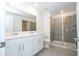 Modern bathroom with white cabinets, double vanity, and a large shower at 4278 Green Gables Pl, Kissimmee, FL 34746