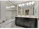 Modern bathroom with double vanity, large mirror, and walk-in shower at 4838 Romeo Cir, Kissimmee, FL 34746