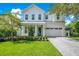 Two-story farmhouse style home with white siding, gray roof, and a paved driveway at 1840 Biscayne Dr, Winter Park, FL 32789