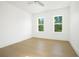 Bright bedroom with light hardwood floors and two large windows at 1840 Biscayne Dr, Winter Park, FL 32789