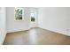 Spacious bedroom with light hardwood floors and two windows at 1840 Biscayne Dr, Winter Park, FL 32789