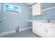 Laundry room with white cabinets, blue walls, and patterned floor at 1840 Biscayne Dr, Winter Park, FL 32789