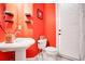 Small bathroom with coral walls, white sink and toilet at 10527 Emerald Chase Dr, Orlando, FL 32836