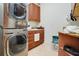 Laundry room with stacked washer and dryer, cabinets and sink at 10527 Emerald Chase Dr, Orlando, FL 32836