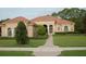 One-story home with tile roof, arched entryway, and landscaped yard at 136 Osprey Hammock Trl, Sanford, FL 32771