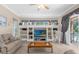 Living area with built-in shelving, hardwood floors, and access to a patio at 277 Olivia Rose Ct, Lake Mary, FL 32746