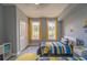 Bright bedroom with two twin beds, ample natural light, and gray walls at 7673 Heritage Crossing Way # 101, Reunion, FL 34747