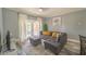 Comfortable living room with gray sectional, patio access, and kitchen view at 7673 Heritage Crossing Way # 101, Reunion, FL 34747