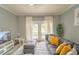 Living room features gray sectional sofa, sliding glass doors and patio access at 7673 Heritage Crossing Way # 101, Reunion, FL 34747