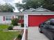 House exterior with red garage door and white picket fence at 713 W 2Nd St, Lakeland, FL 33805