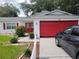 House exterior with red garage door and white picket fence at 713 W 2Nd St, Lakeland, FL 33805