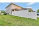 Tan two-story house with white vinyl fence and green lawn at 1624 Hawksbill Ln, Saint Cloud, FL 34771
