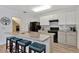 Modern kitchen with granite countertops, black appliances, and an island with seating at 1624 Hawksbill Ln, Saint Cloud, FL 34771