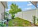 Small, fenced backyard with grass, plants, and a patio area at 1624 Hawksbill Ln, Saint Cloud, FL 34771