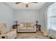 Cozy living room with a loveseat, armchair, and ceiling fan at 1624 Hawksbill Ln, Saint Cloud, FL 34771