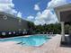 Community pool with lounge chairs and a pergola at 10420 Kiplinger Ln # 238, Orlando, FL 32829