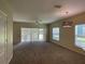 Spacious living room with carpeting, sliding glass doors to patio, and ceiling fan at 10420 Kiplinger Ln # 238, Orlando, FL 32829
