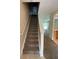 View of carpeted staircase leading to upper level, with glimpses of living area and kitchen at 10420 Kiplinger Ln # 238, Orlando, FL 32829