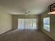 Spacious living room with carpeting, sliding glass doors to patio, and ceiling fan at 10420 Kiplinger Ln # 238, Orlando, FL 32829