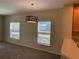 Living area showcasing large windows, pendant light, and carpet flooring at 10420 Kiplinger Ln # 238, Orlando, FL 32829
