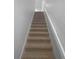 Carpeted staircase with neutral-colored walls and railing at 2323 Arbor Lakes Cir # 2323, Sanford, FL 32771