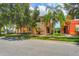 Two-story tan and orange house with palm trees and a grassy yard at 491 Las Fuentes Dr, Kissimmee, FL 34746