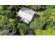 Aerial view of a house nestled in a wooded area, showcasing its metal roof and secluded setting at 1205 Sutton Trl, Geneva, FL 32732