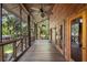 Large screened porch with wooden floors and access to backyard at 1205 Sutton Trl, Geneva, FL 32732